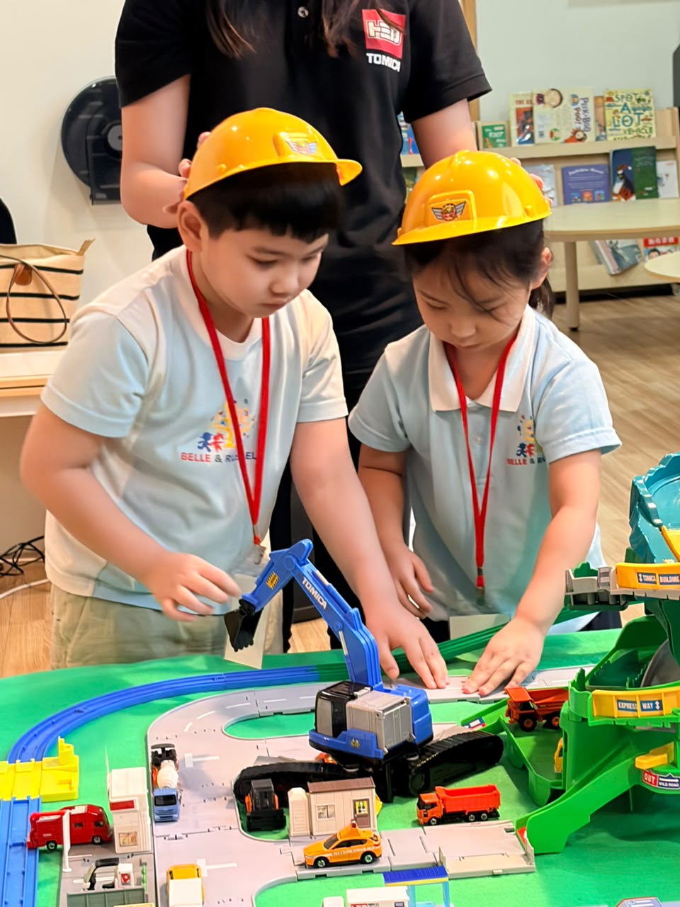 Children wearing builder's hats engaged in intentional play at Belle & Russell