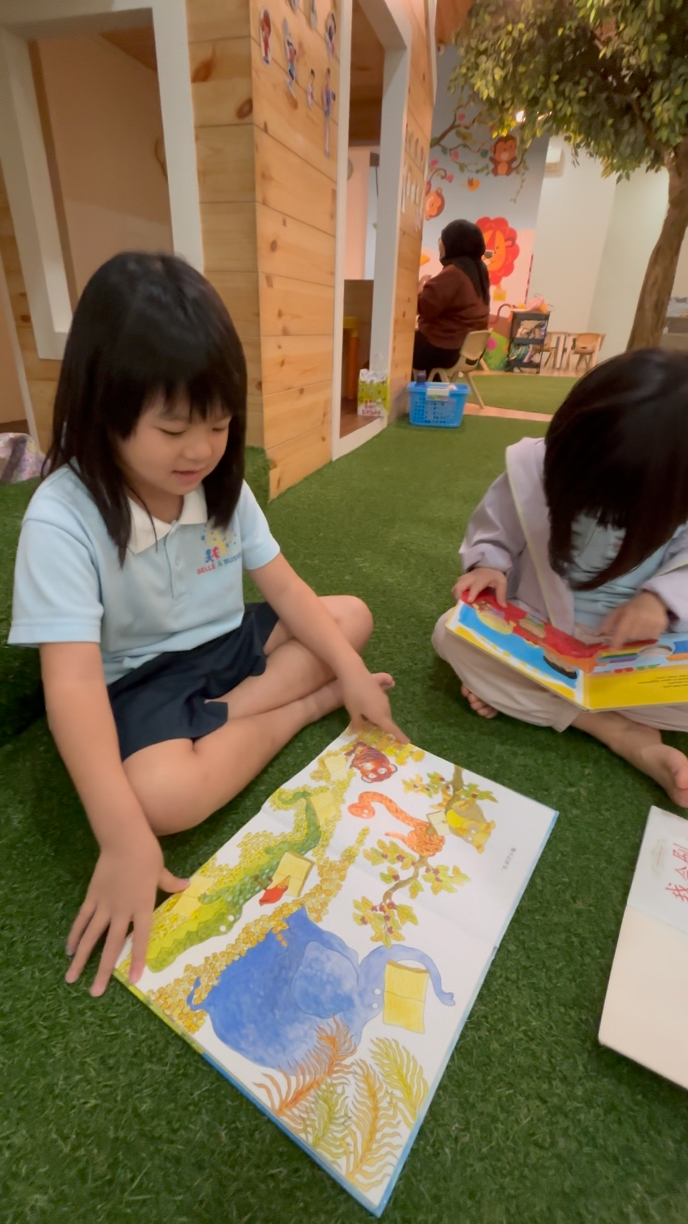 A child reading a picture book one-to-one at Belle & Russell